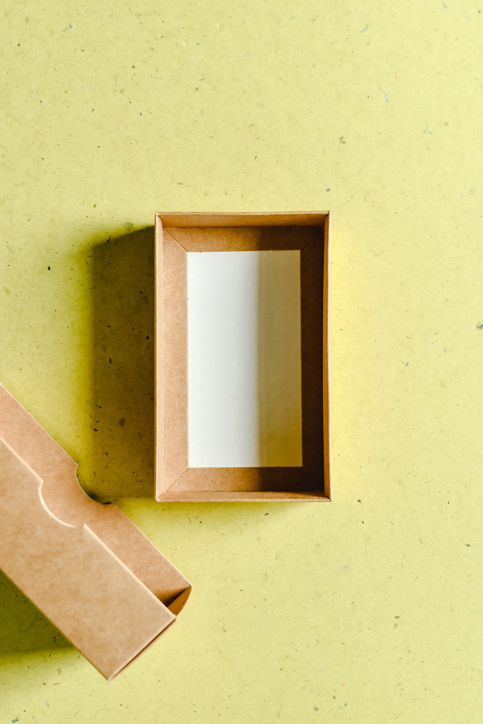 Caixa de papel kraft aberta sobre fundo colorido