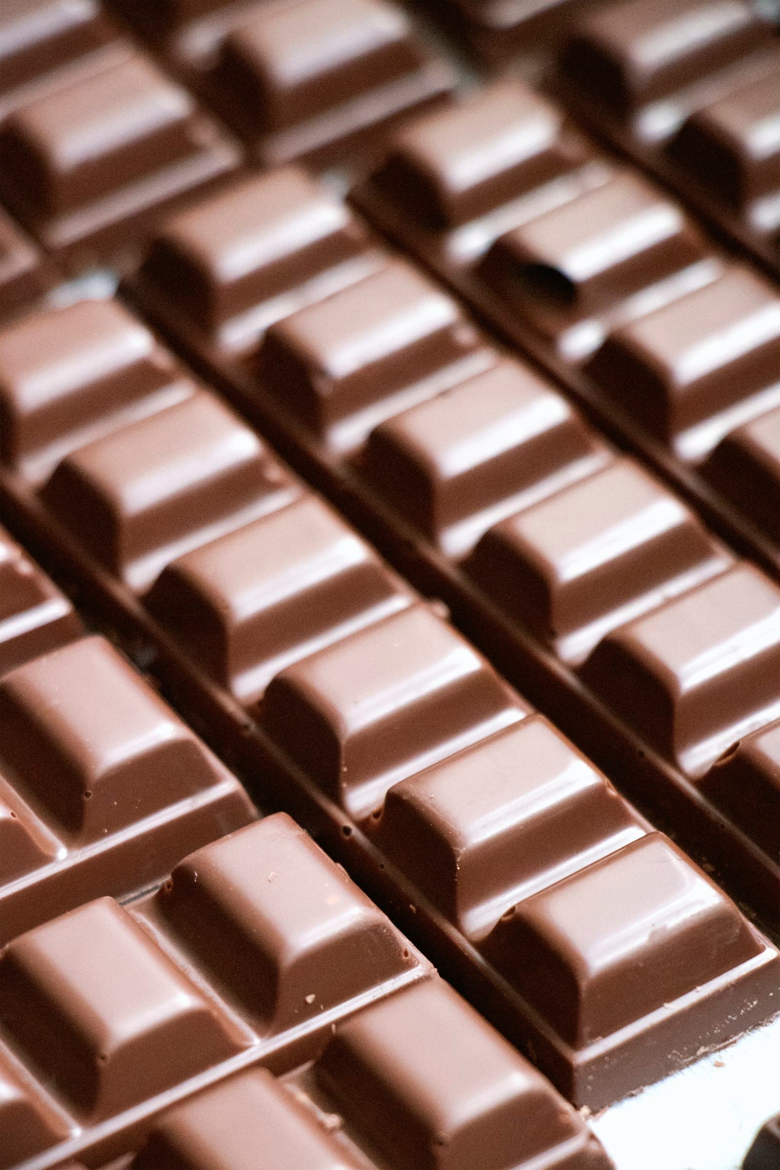 Fileiras de quadrados de chocolate brilhante, bem temperado